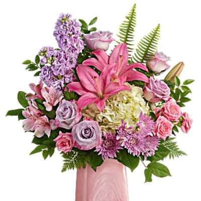 Pink and lavender bouquet with lilies, roses, and hydrangea in a tall pink ceramic vase