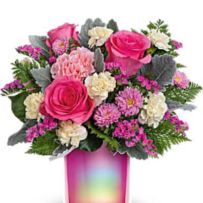 Bright pink and cream mixed flower arrangement in an iridescent pink glass vase