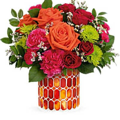 Bright bouquet of orange roses, red roses, pink carnations, and green mums in an orange mosaic vase