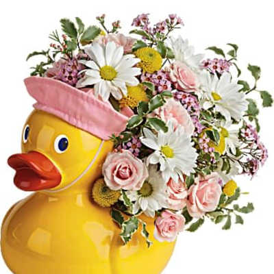 Playful arrangement of pink and white flowers in a yellow ceramic duck container with a pink cap.