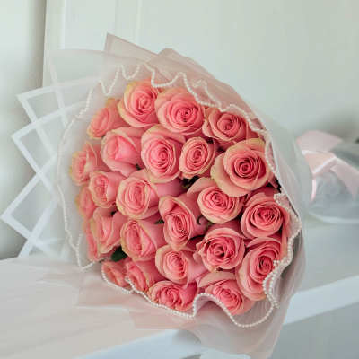 Bouquet of pink roses wrapped in sheer pink paper