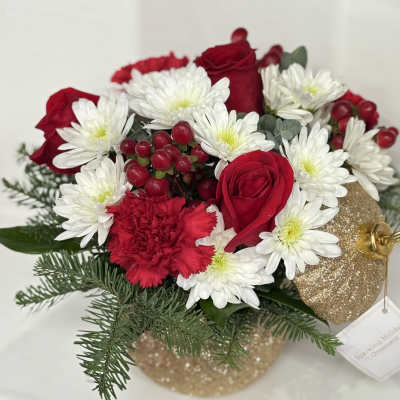 Red roses and white daisies in a glittery gold ornament container