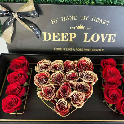 Heart-shaped rose box with red and cream roses in a black gift box