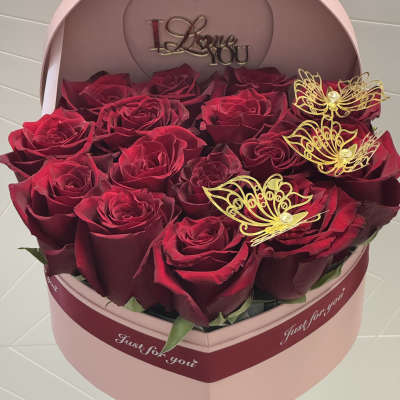 Heart-shaped box of red roses with gold butterfly decorations