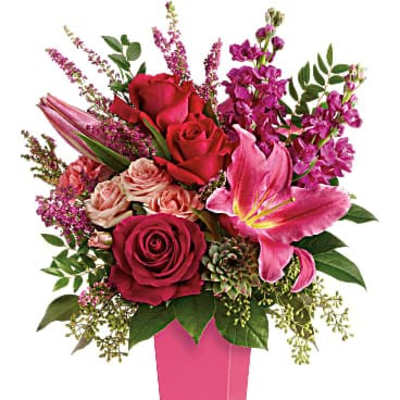 Pink and red floral arrangement in a tall pink vase