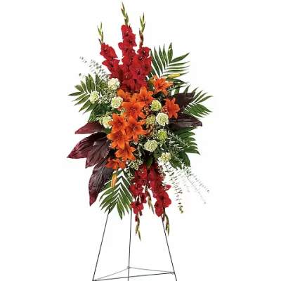 Tall floral standing spray with red and orange flowers on an easel