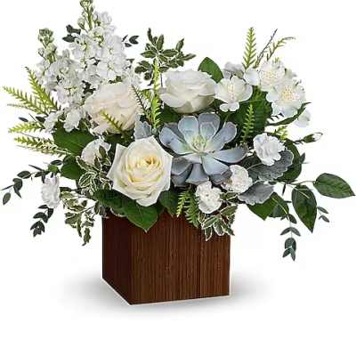 White roses and mixed white flowers in a wooden cube vase