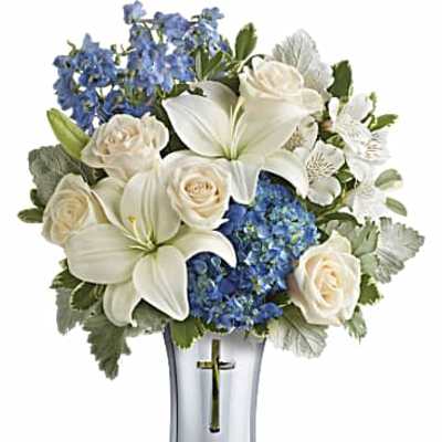 White lilies and cream roses with blue flowers in a silver vase