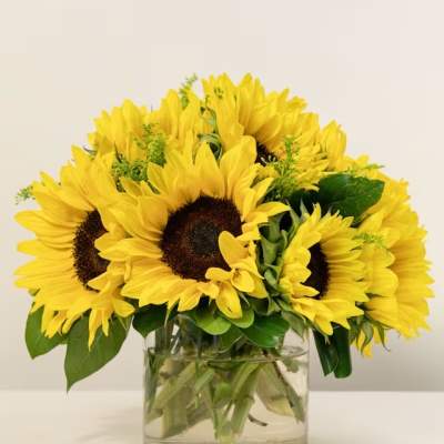 Bouquet of yellow sunflowers in a clear glass vase