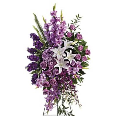 Tall purple and white funeral spray on a stand