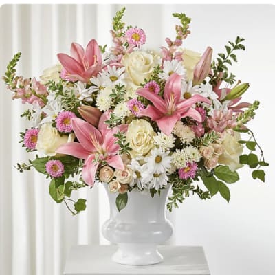 Pink lilies and mixed white and pink flowers in a white vase