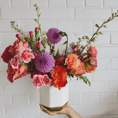 Colorful bouquet in a white vase with pink, orange, and purple blooms