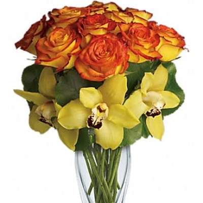 Yellow orchids and orange-yellow roses arranged in a clear glass vase