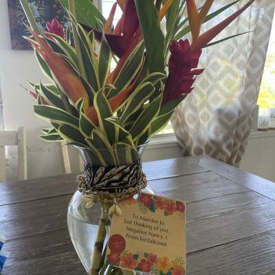 Tropical bouquet in a glass vase with a gift tag