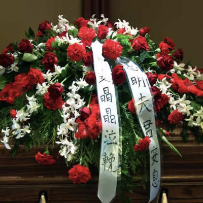 Large red and white floral funeral spray with ribbon streamers