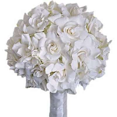 Round hand-tied bouquet of white roses with stems wrapped in white ribbon