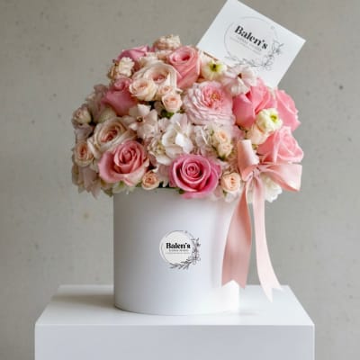 Pink and white rose bouquet in a white hat box with a ribbon
