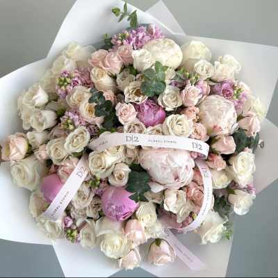 Bouquet of blush and white roses with peonies wrapped in white paper
