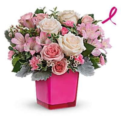 Short pink and white rose arrangement with mixed blooms in a bright pink cube vase