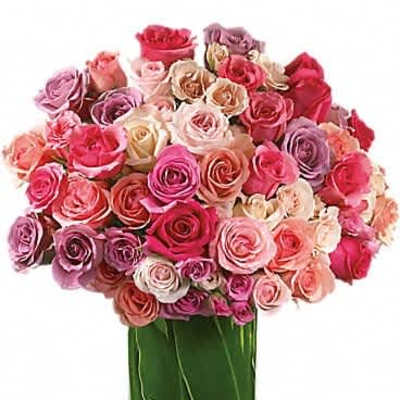 Dense bouquet of mixed pink, peach, and lavender roses in a clear glass cylinder vase