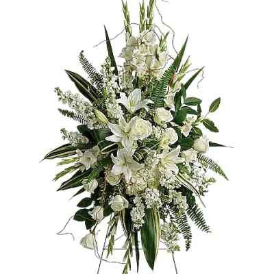 White floral standing spray on an easel with lilies and roses