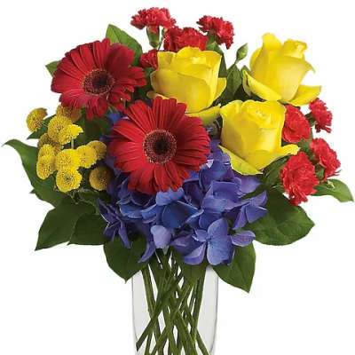 Bouquet of yellow roses, red gerbera daisies, and blue hydrangeas in a clear vase