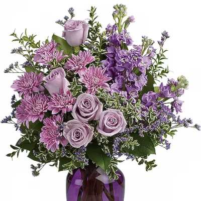 Lavender roses and purple flowers in a purple glass vase