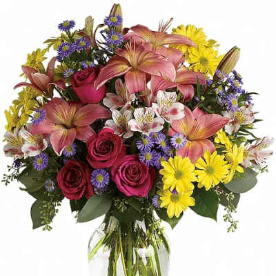 Mixed bouquet of pink lilies, roses, and yellow daisies in a glass vase