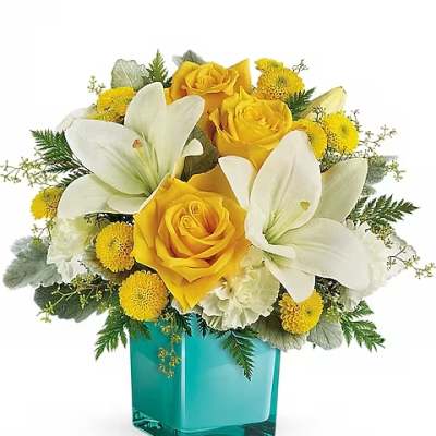 Yellow roses and white lilies in a turquoise glass vase