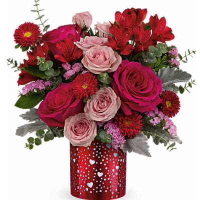 Bouquet of pink and red roses with red daisies in a heart-patterned vase