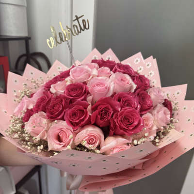 Bouquet of pink and hot pink roses wrapped in pink paper
