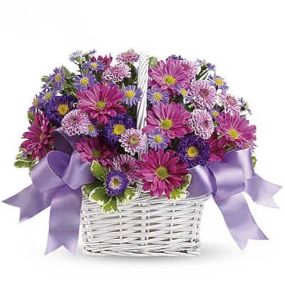 Purple and pink daisy bouquet in a white basket with lavender ribbon