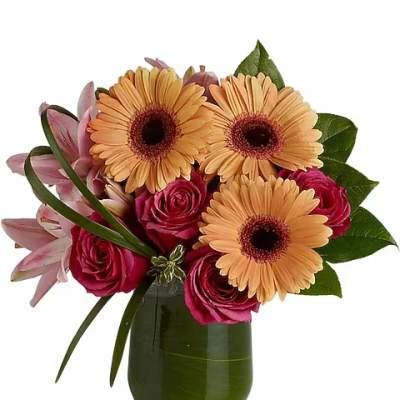 Bouquet of peach gerbera daisies and pink roses in a green glass vase