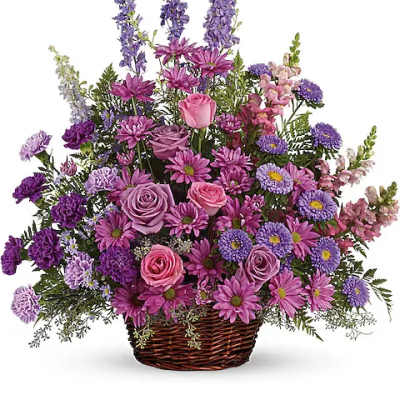 Purple and pink mixed flower arrangement in a wicker basket