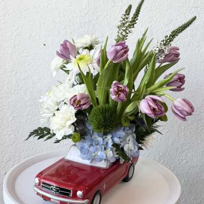 Flowers arranged in a red toy car planter