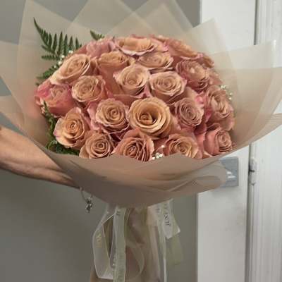 Bouquet of peach roses wrapped in translucent paper