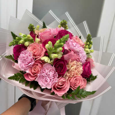 Pink rose and carnation bouquet wrapped in pale pink paper