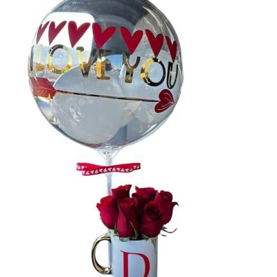 Red roses in a white D-initial mug with an 'I love you' heart balloon attached.