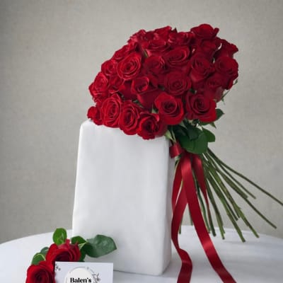 Bouquet of red roses tied with a red ribbon, with a matching rose boutonniere below