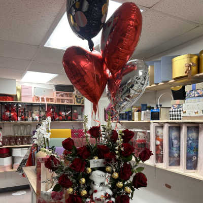 Red rose arrangement with a teddy bear and heart balloons