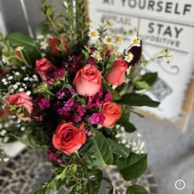 Bouquet of pink and coral roses with small white daisies