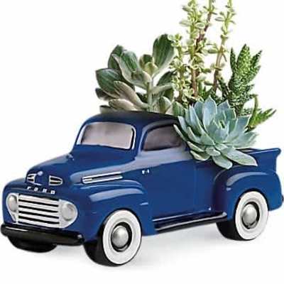 Blue ceramic vintage truck planter filled with assorted succulents in the truck bed
