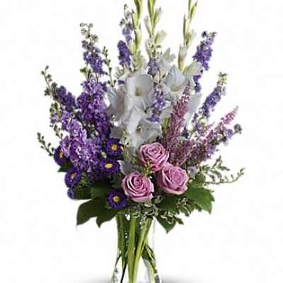 Purple and white floral arrangement in a clear glass vase
