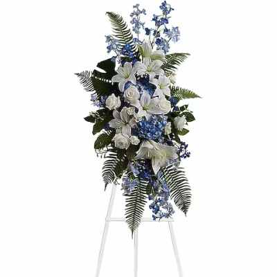 Tall white and blue floral standing spray on an easel