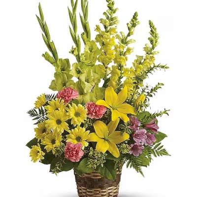 Yellow and pink mixed flower arrangement in a woven basket