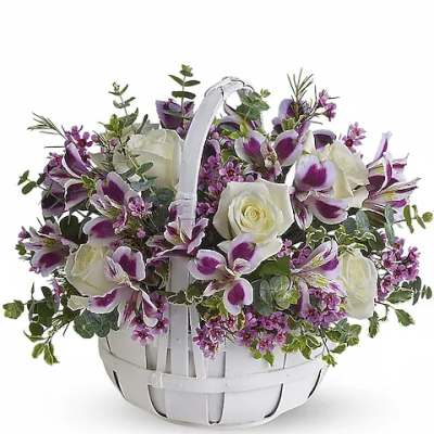 White basket of purple and white flowers with a handle