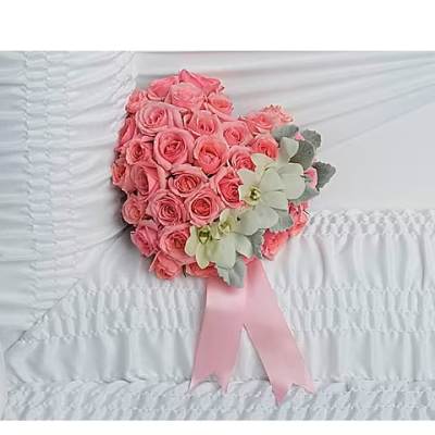 Pink rose bouquet with pale flowers and a pink ribbon on white bedding