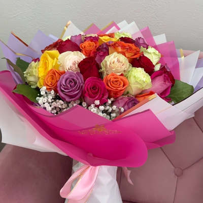 Bouquet of multicolored roses wrapped in pink and white paper