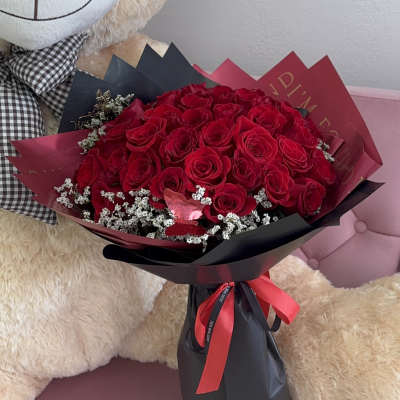 Bouquet of red roses wrapped in black and burgundy paper