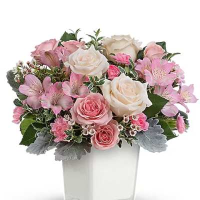Pink and white rose bouquet in a clear square vase